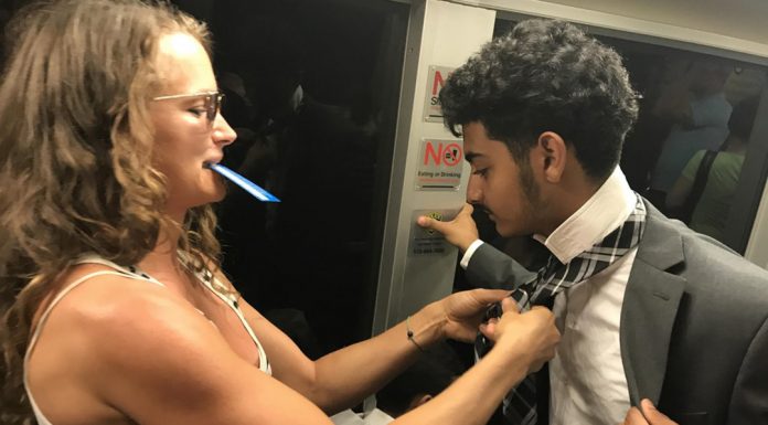 Fellow Passenger Helps Young Man With His Tie On Train